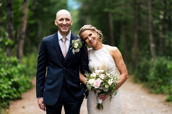 Newlyweds look at the camera during Banff Wedding Photography