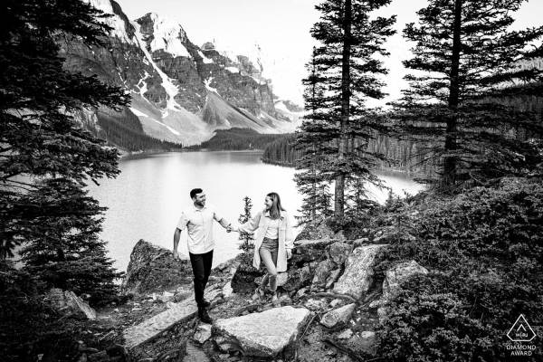 Engagement Photograph taken at Moraine Lake of couple walking and holding hands.