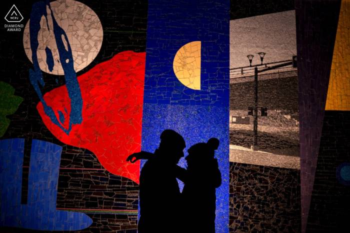 silhouetted couple against the colorful and unique mosaic wall in Calgary.