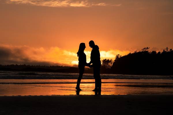 Married couple look at each other during romantic sunset in Banff