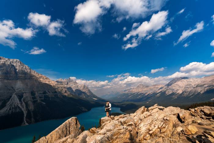 Couple stands on the rock during engagement session in Banff