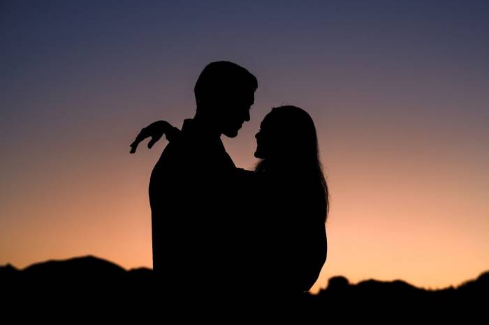 silhouetted engaged couple during amazing sunrise