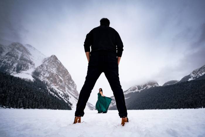 Creative Banff Engagement Photograph at Lake Louise. Lady dances for her Fiancee.