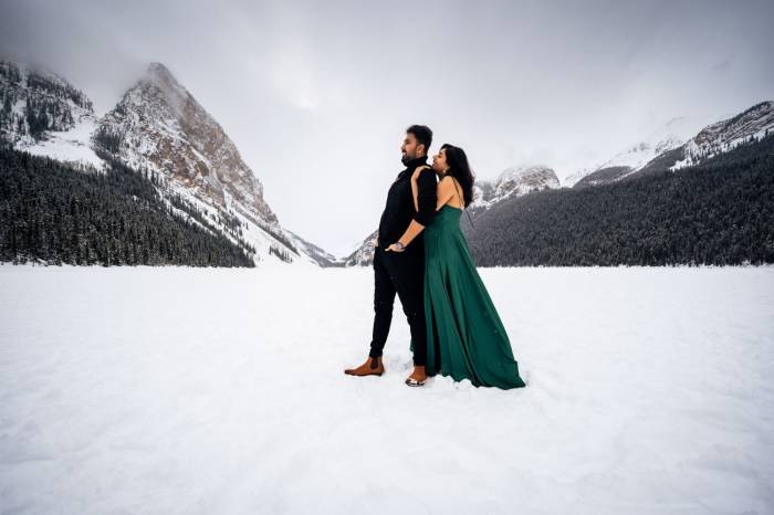 Couple in love in a hug at the frozen Lake Louise in Banff.