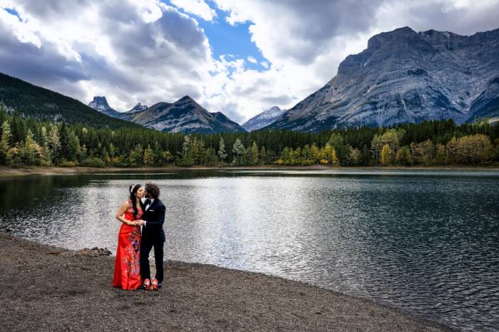Bride and groom are kissing surrounded by the Canadian Rockies
