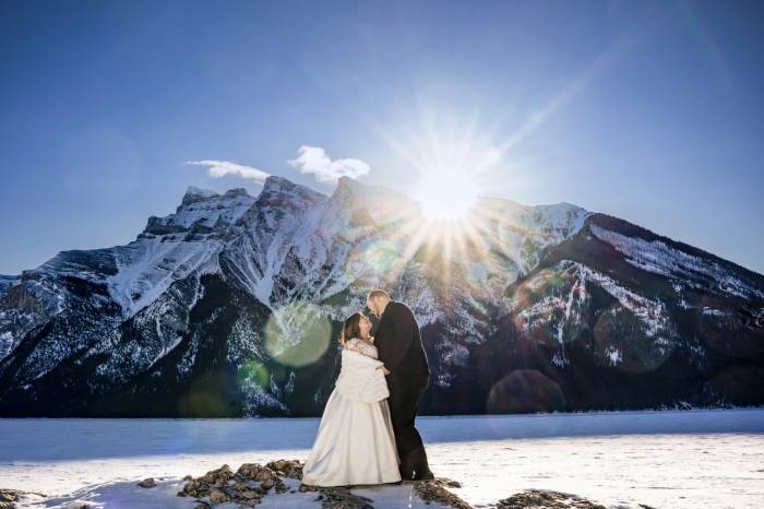 Bride and groom in a hug at the beautiful Minnawanka Lake. Photograph captured by the best Calgary Wedding Photographer.