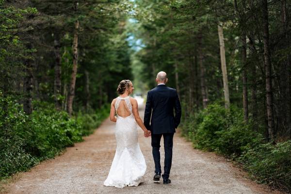 Newlyweds walking in the forest in during Canmore bridal party.