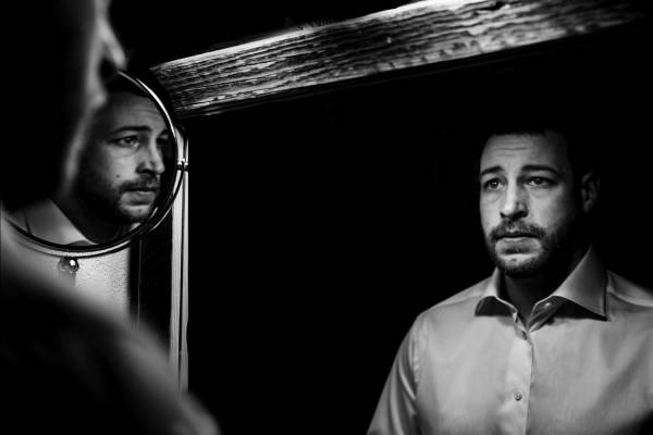 creative photography of the groom. Mirror reflections in black and white.