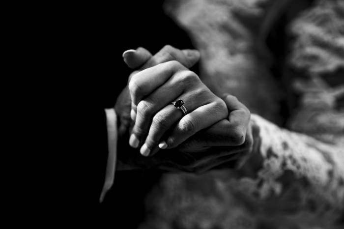 Newly weds holds their hands on which we can see a wedding ring.