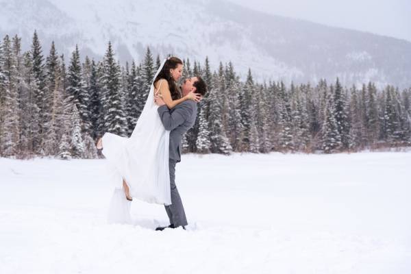 The groom lifting his wife and looking into her eyes in during winter photo session with 4eyes photography