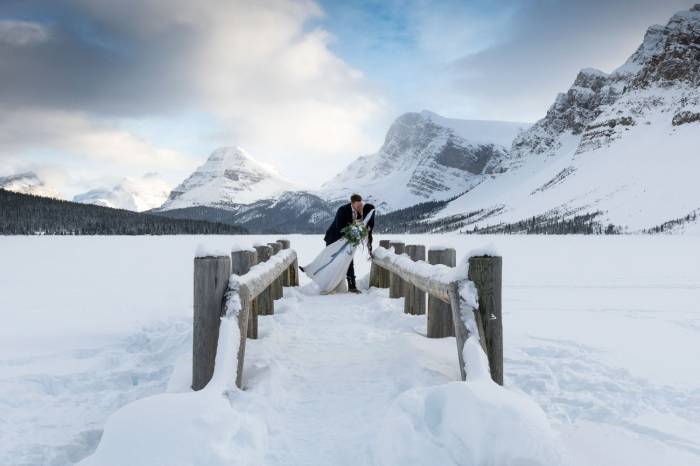Groom are kissing the bride on the bridge after wedding ceremony in Banff.