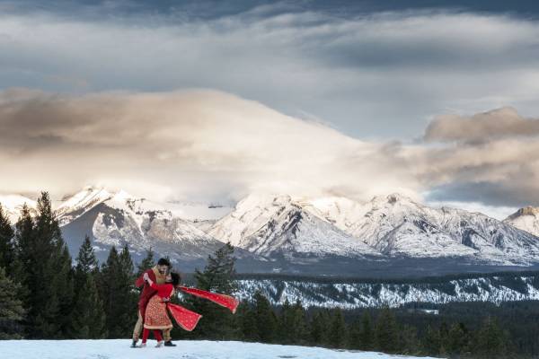Married couple perform traditional Indian dance during their after wedding photo session in Banff.