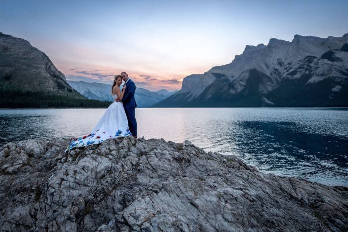 Newlyweds hugging each other during after wedding photo shoot at Minnewanka Lake.