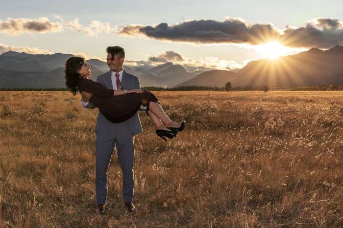 A man carry his new fiancée on his hands during engagement shoot in Banff National Park.