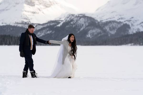 Newlyweds walks in deep snow on their wedding at Bow Lake