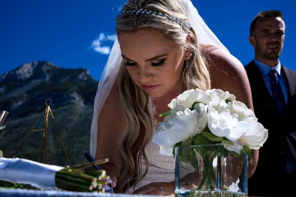 The bride signing the official paper during elopement in Banff