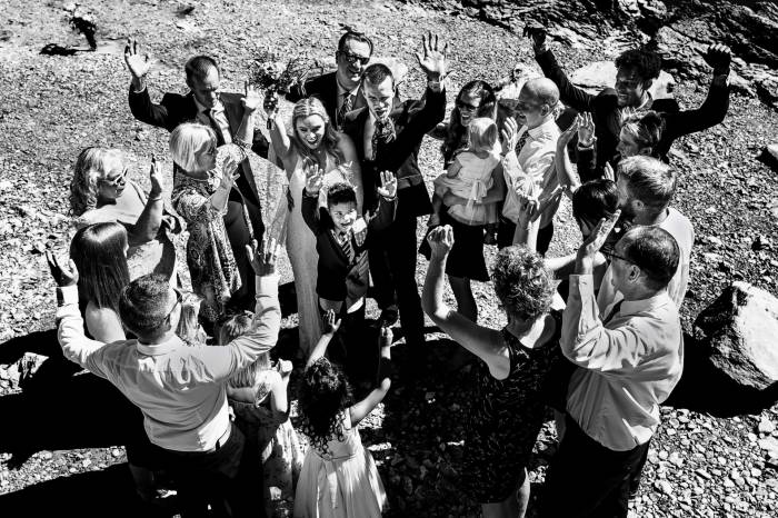 Family wedding photo. Family and friends happy that bride and groom got married. All of them lifted their hands above the heads.