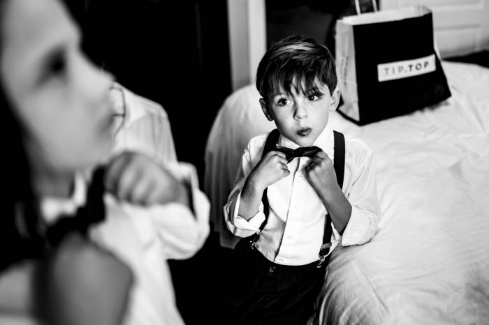 Black and white photograph of boys fixing their ties before Wedding Ceremony in the Canadian Rockies.
