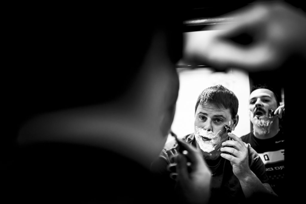 Groom and best men shave their faces at the same time. Black and white Calgary Wedding Photography. | 4Eyes Photography
