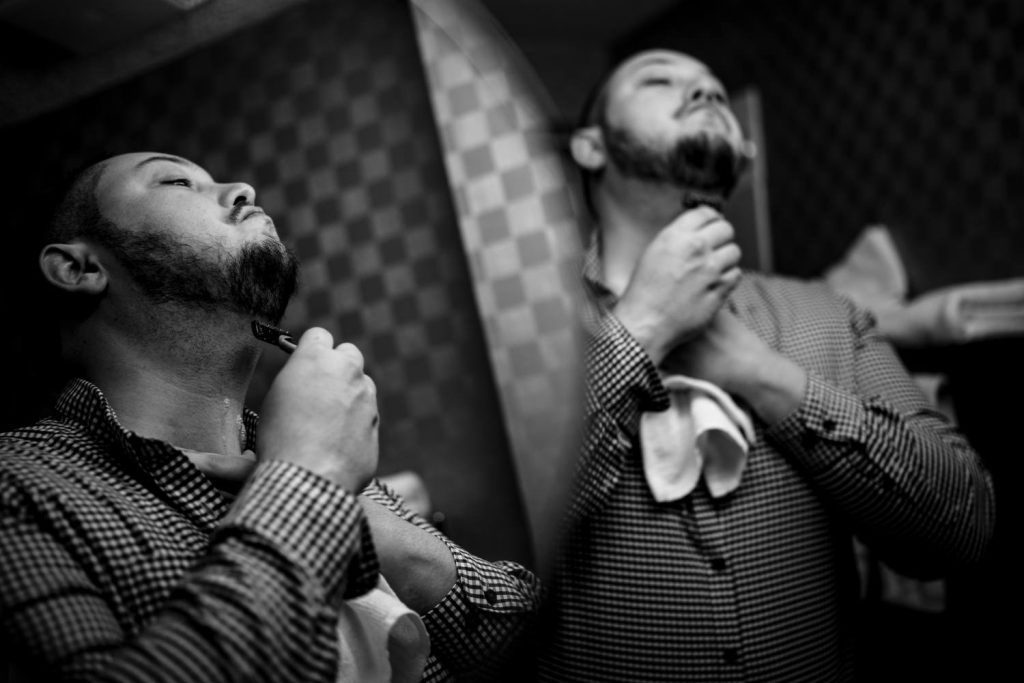 Creative Banff Wedding Photography of the groom shaving his face in a doubled mirror. | 4Eyes Photography