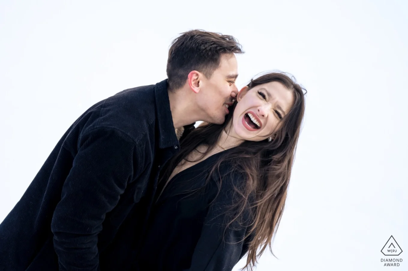 Funny moment of an engaged couple when a man tries to kiss his fiancée's neck.