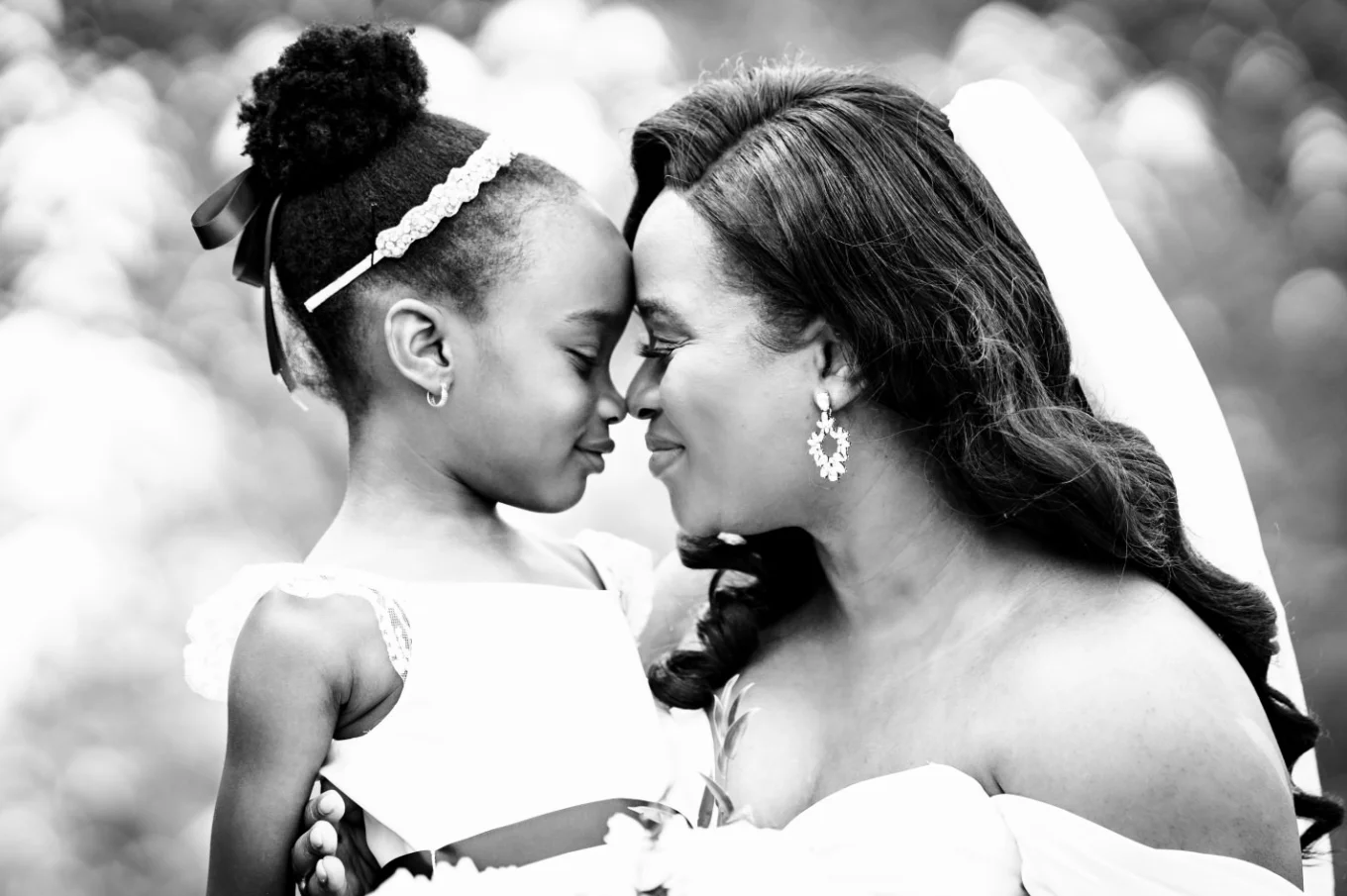Charming photograph in black and white of the bride and her daughter touching their noses.