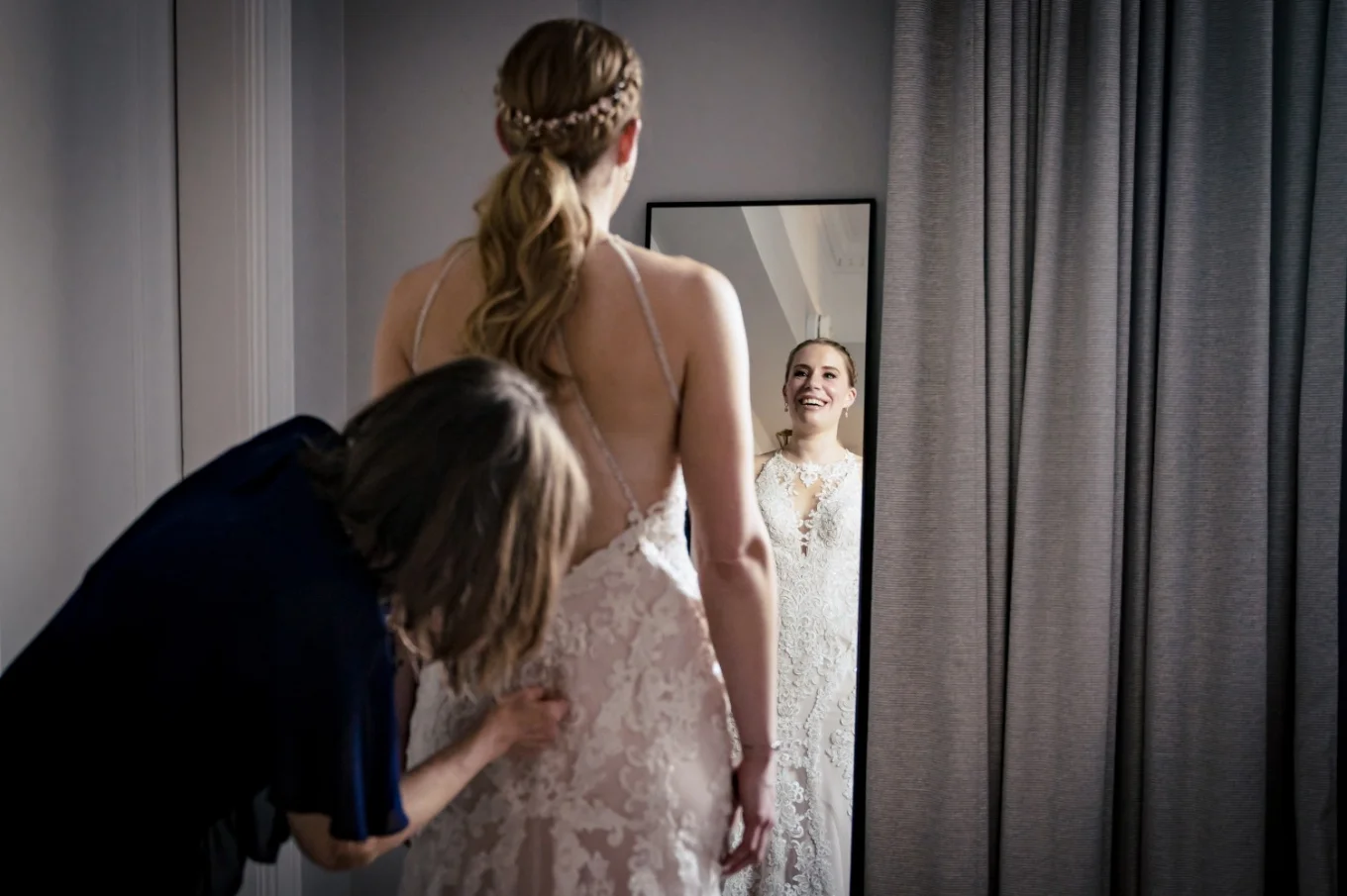 Getting ready time before Banff Wedding Ceremony, Mother of the bride helps with her dress while the bride look at the mirror.