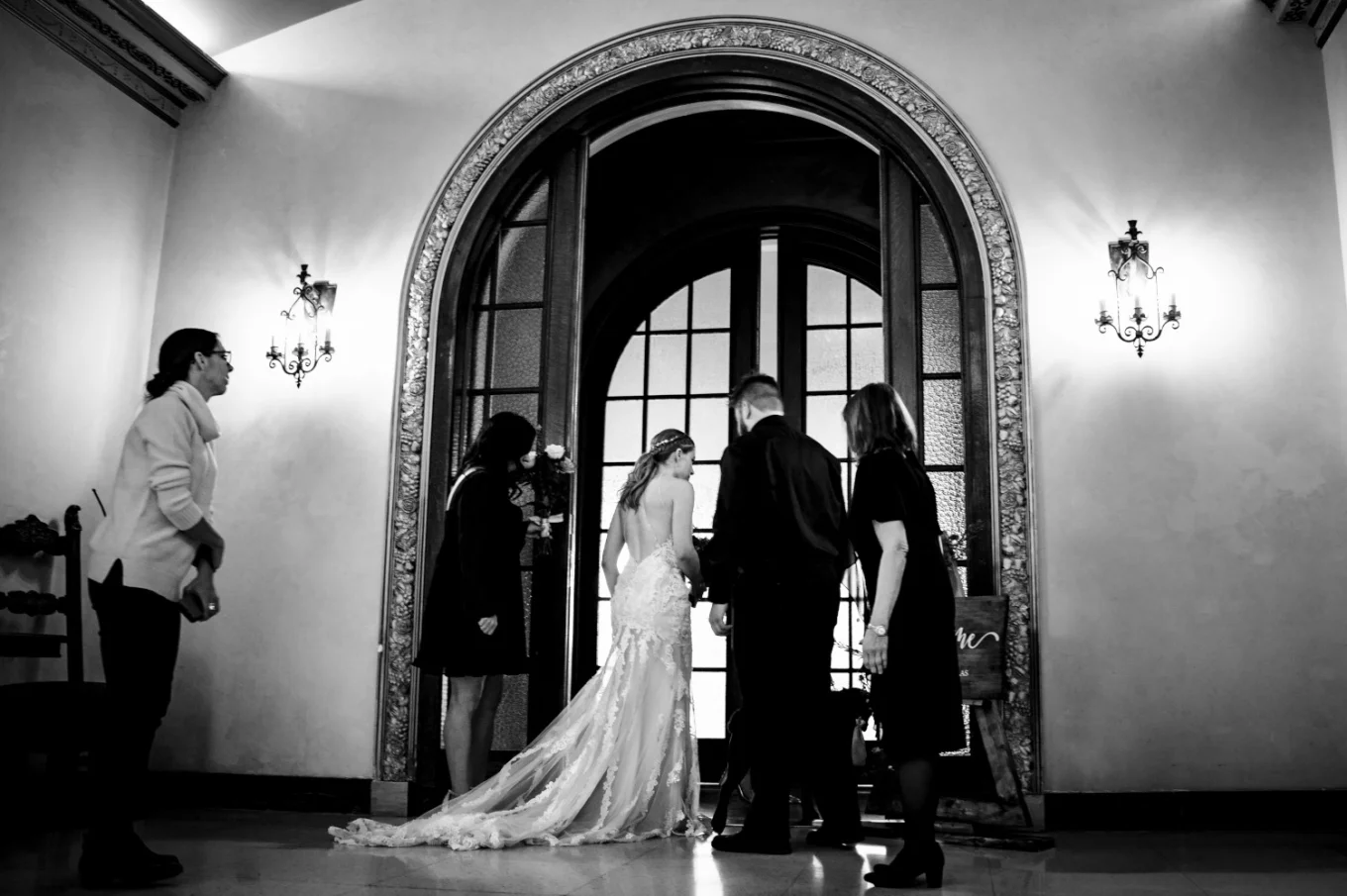 Bride and her family in front of huge door about to enter the Banff Wedding Ceremony at Fairmont Hotel.
