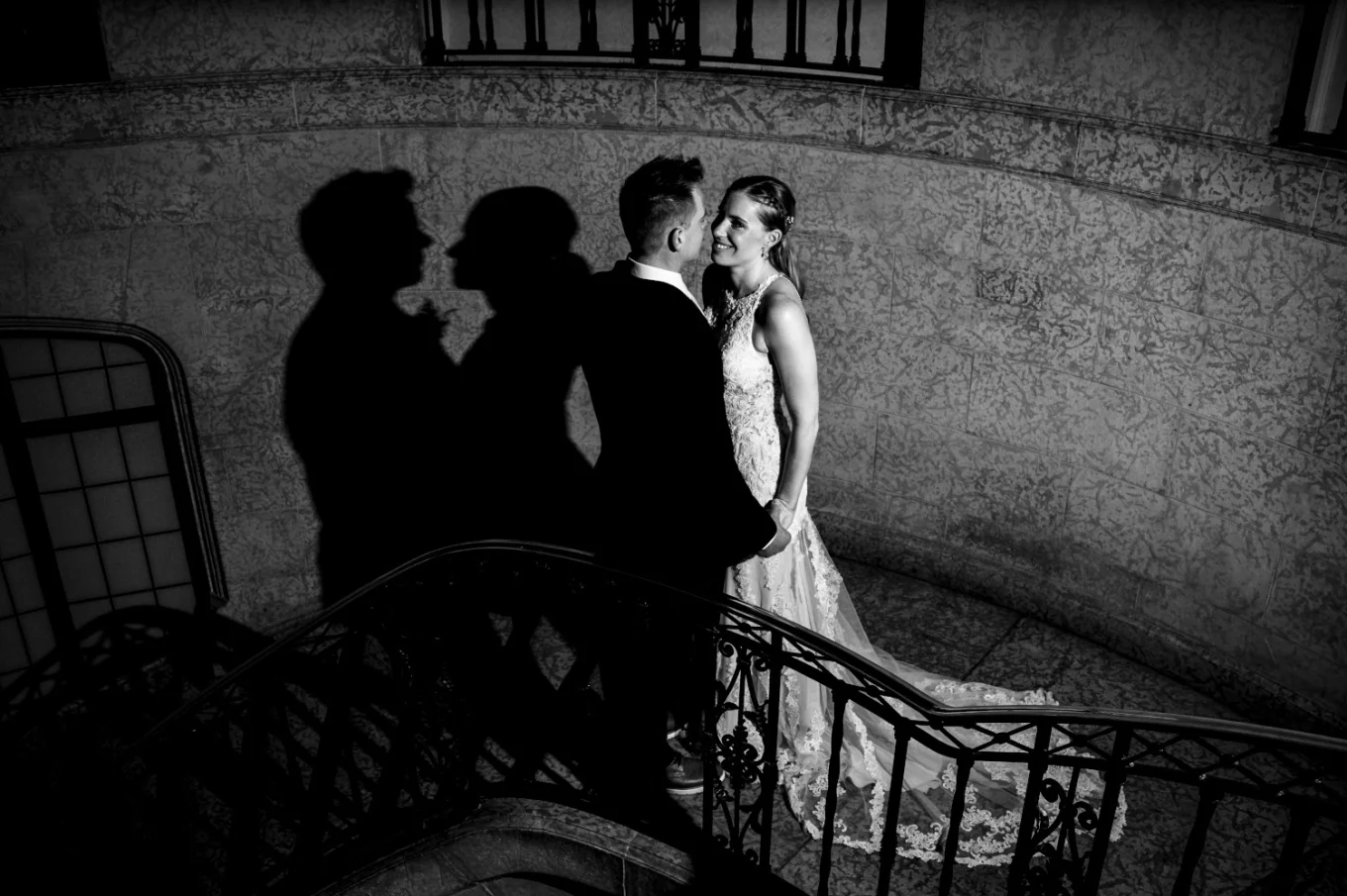 Bride and groom standing on the stairs, facing each other and look deeply into each others eyes during wedding portrait session captured by Banff Wedding Photogarpher.