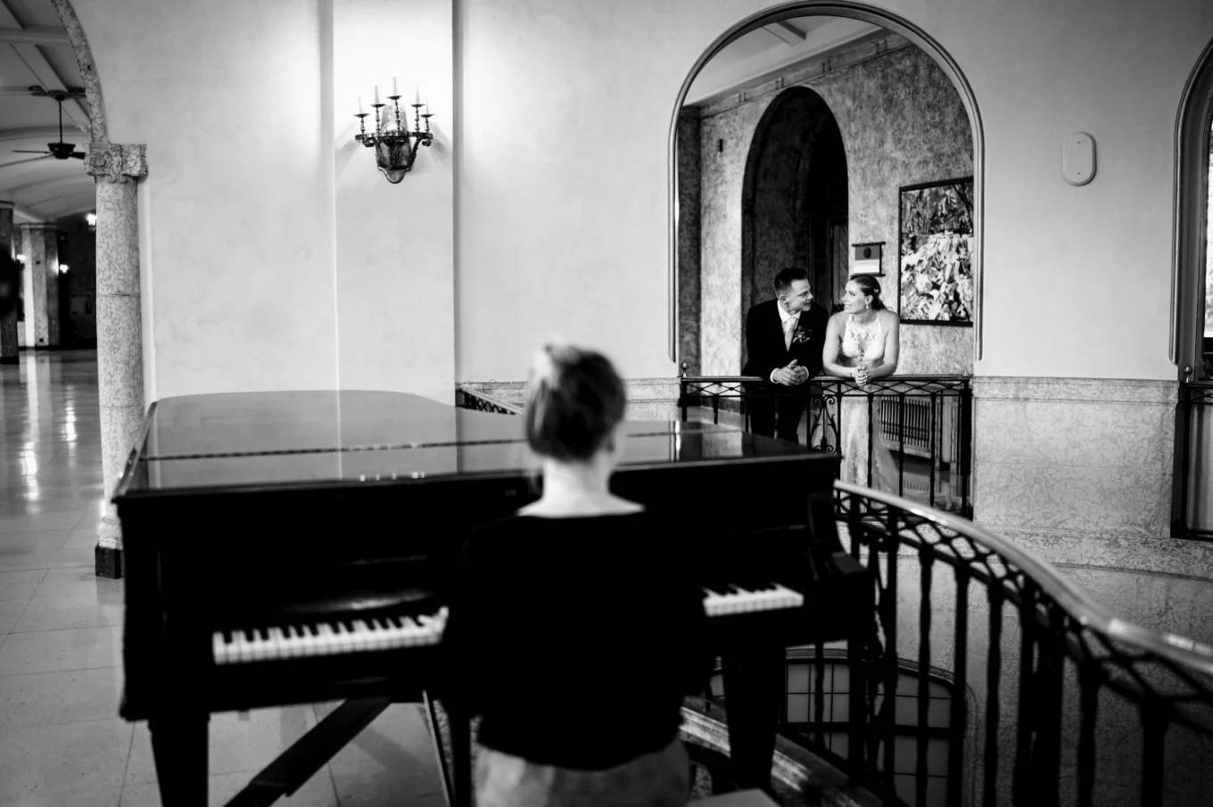 Pianist plays for the newlyweds while they are listing and look at each other with love.
