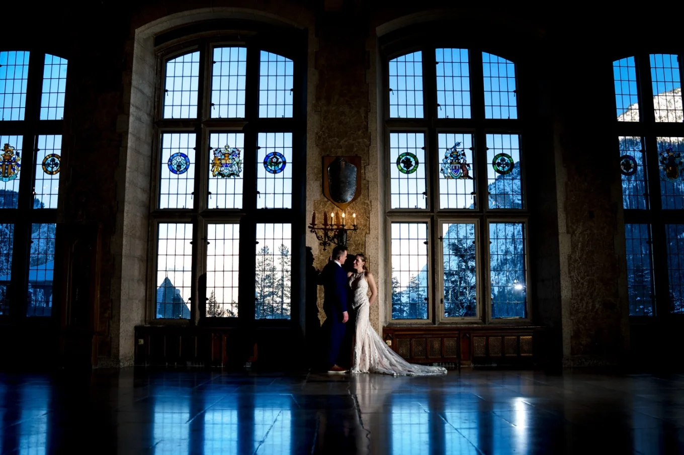 Bride and groom talk nest to the giant and stunning windows at Fairmont Banff Springs.