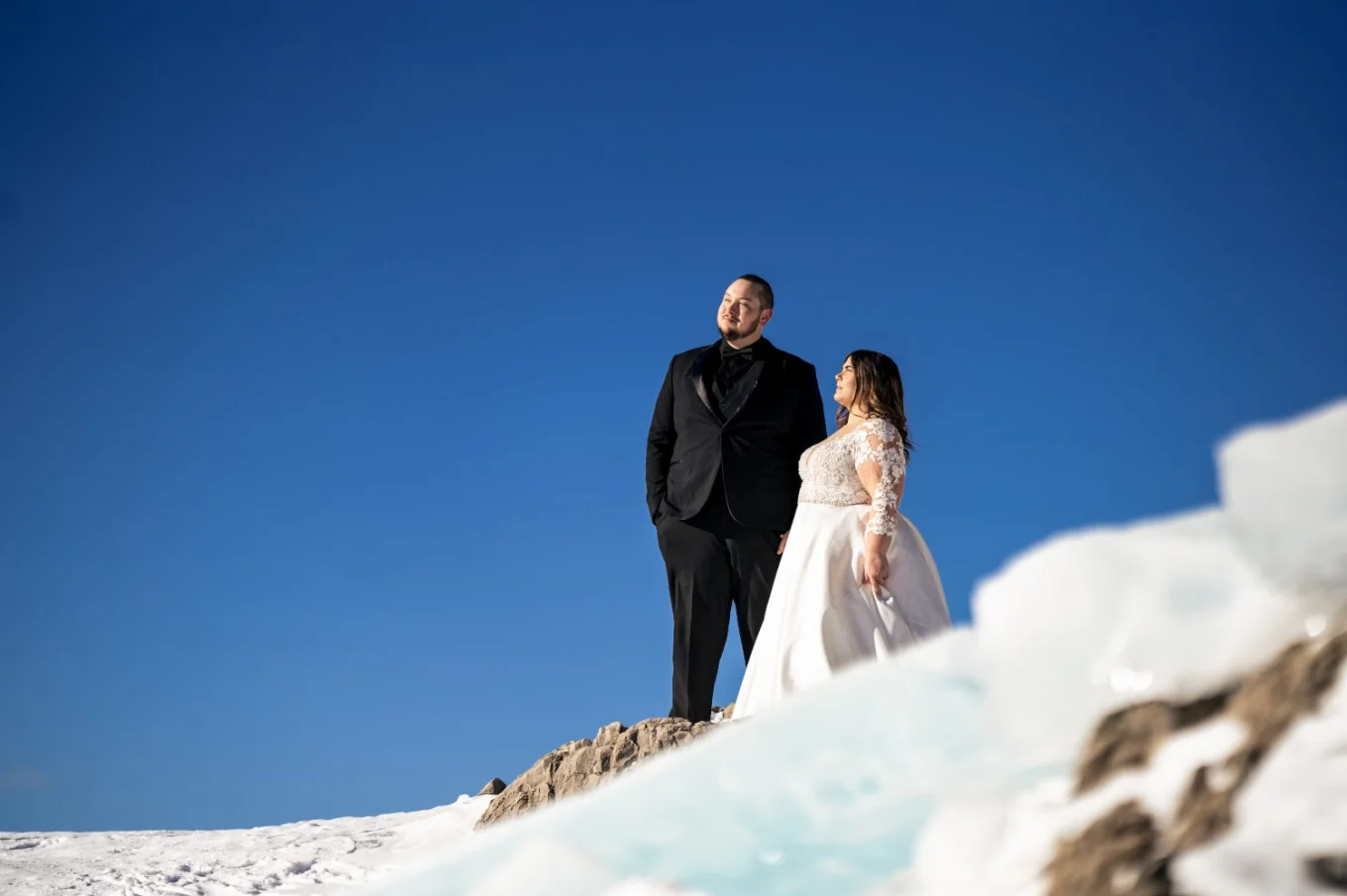 Banff Wedding Photography of the newlyweds standing at the frozen hill.
