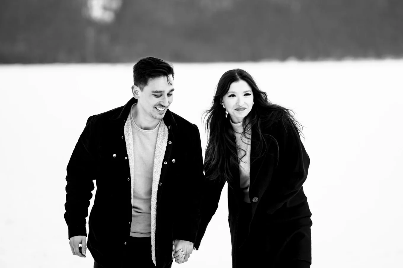 Lifestyle photograph of the young couple walking and holding hands. They look happy.