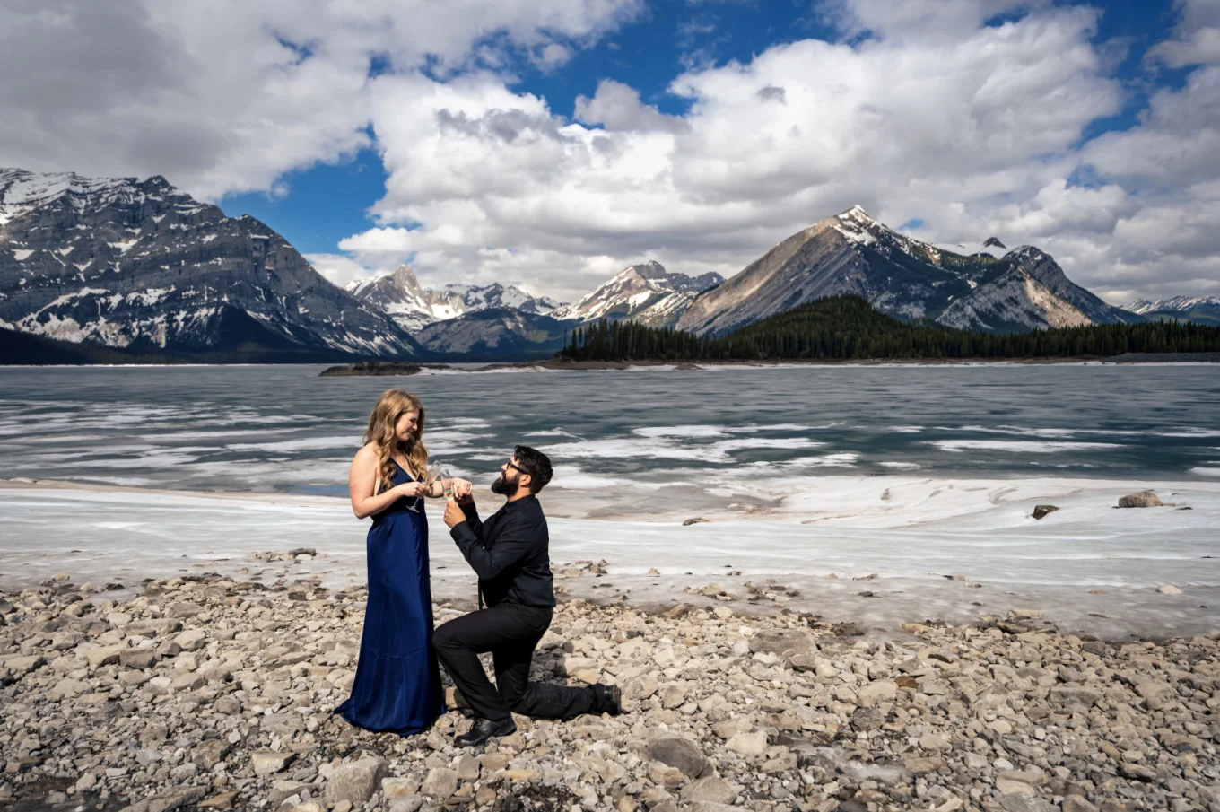 Romantic proposal in Banff. Man goes down the knee with the engagement ring in his hand.