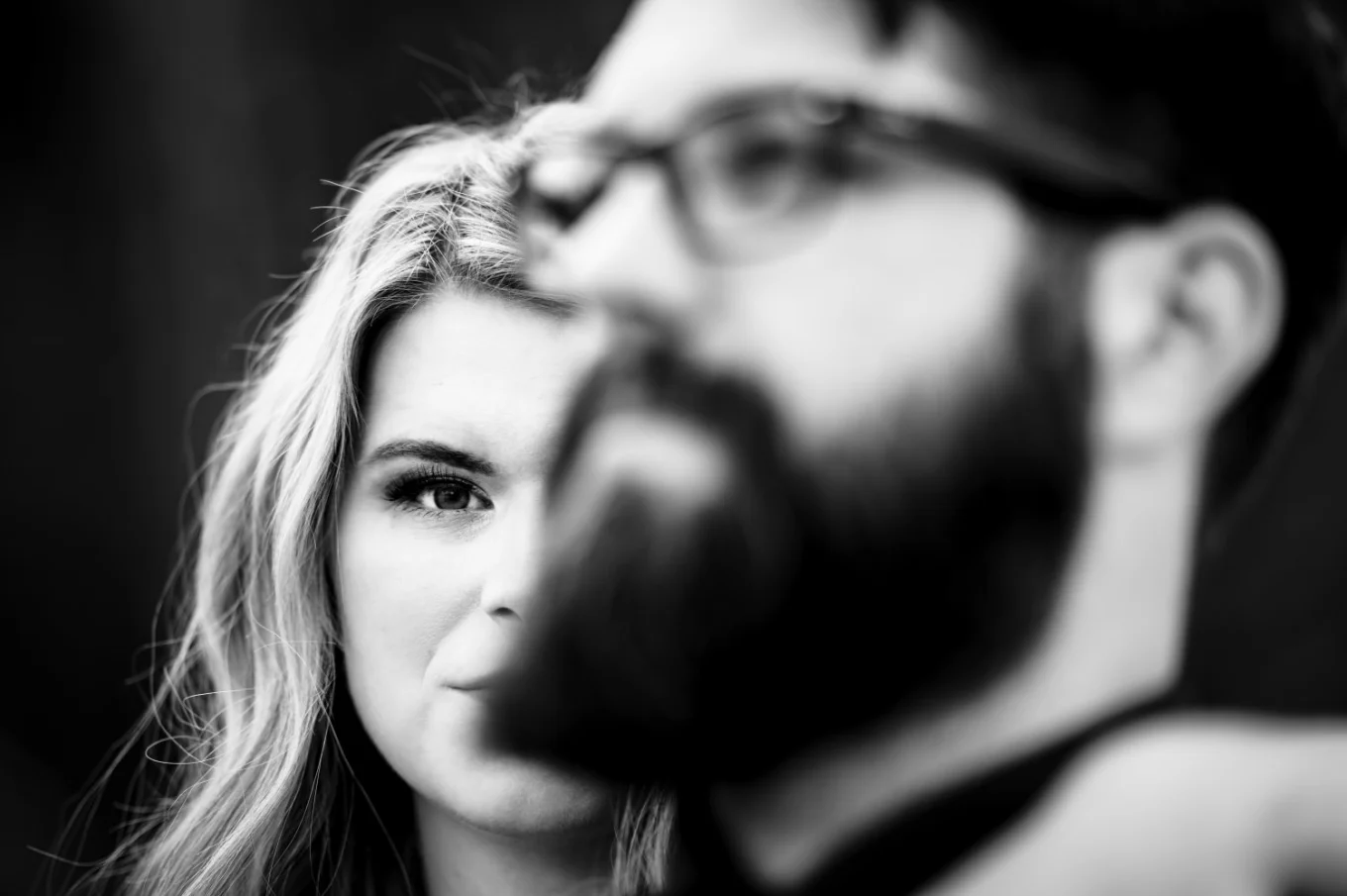 Creative photograph in black and white of the engagement couple when a girl standing behind her fiance with a protective look.