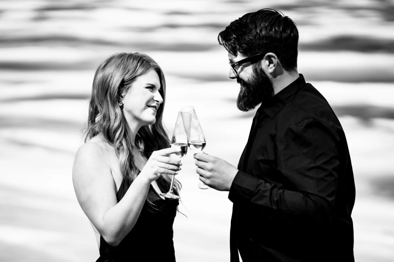 Amazing photograph in black and white of the couple celebrating their love with glasses of champagne.