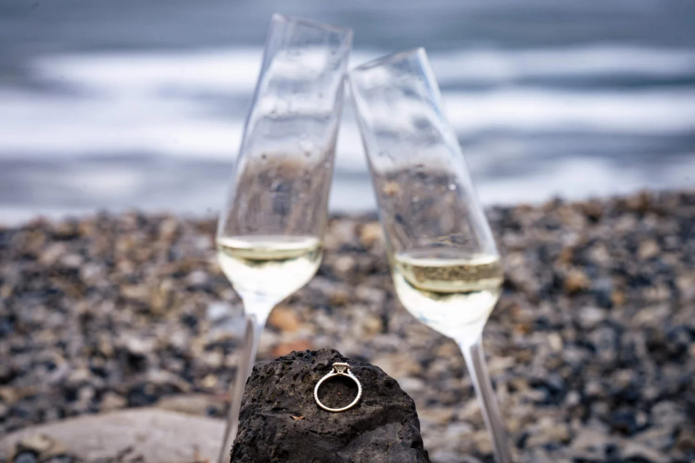 Engagement ring on the rock nest to the glasses on champagne.