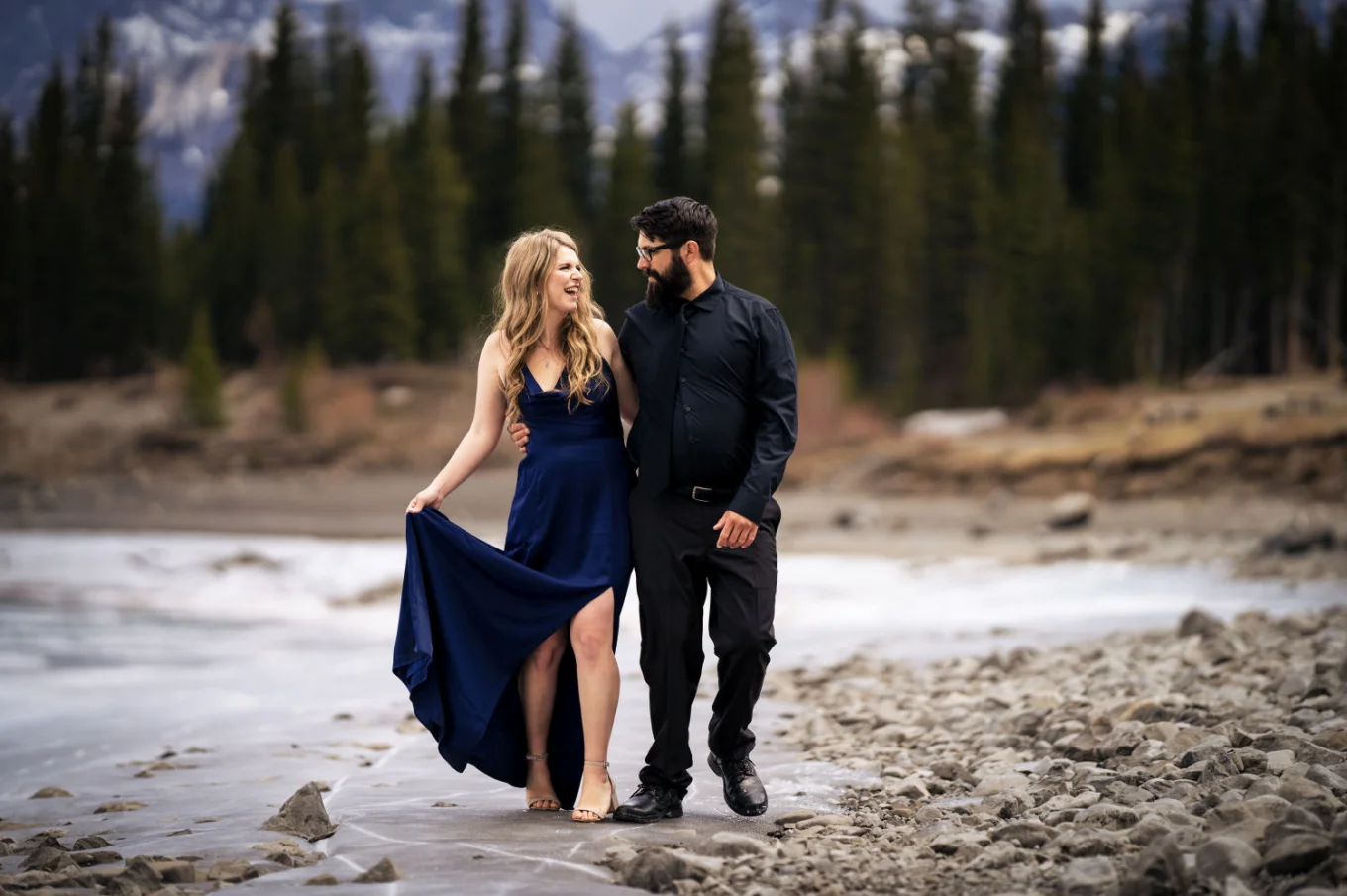 Engaged couple walk down the lake in Banff.