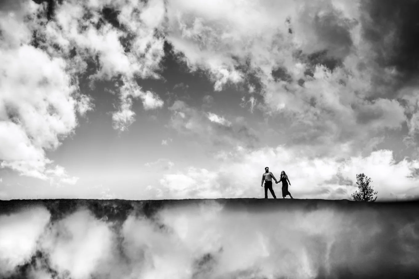 Creative photograph of the couple walking in the clouds.
