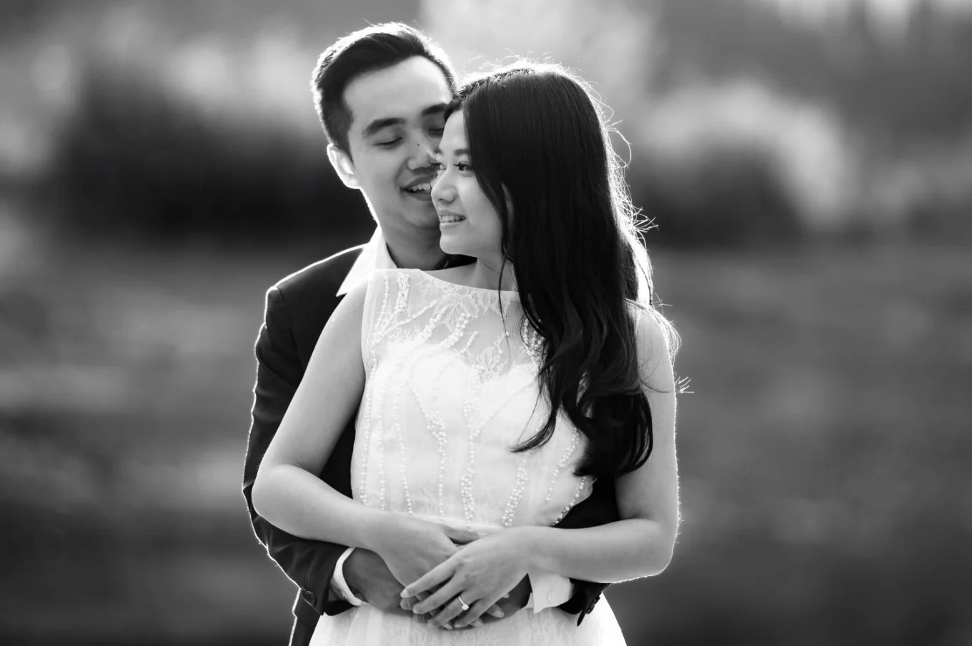 A man hug his fiancee from behind.