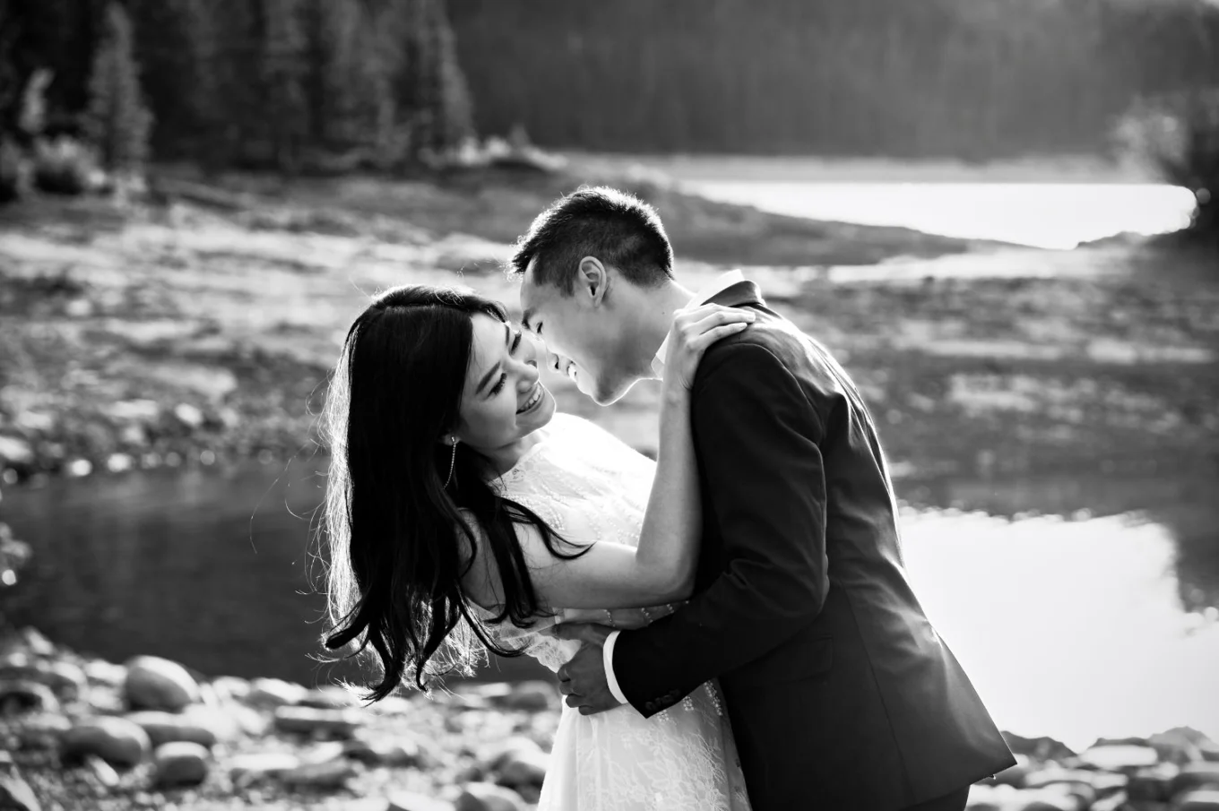 Real moments captured by Banff Wedding Photographer of the engaged couple laughing and hugging at Minnewanka Lake.