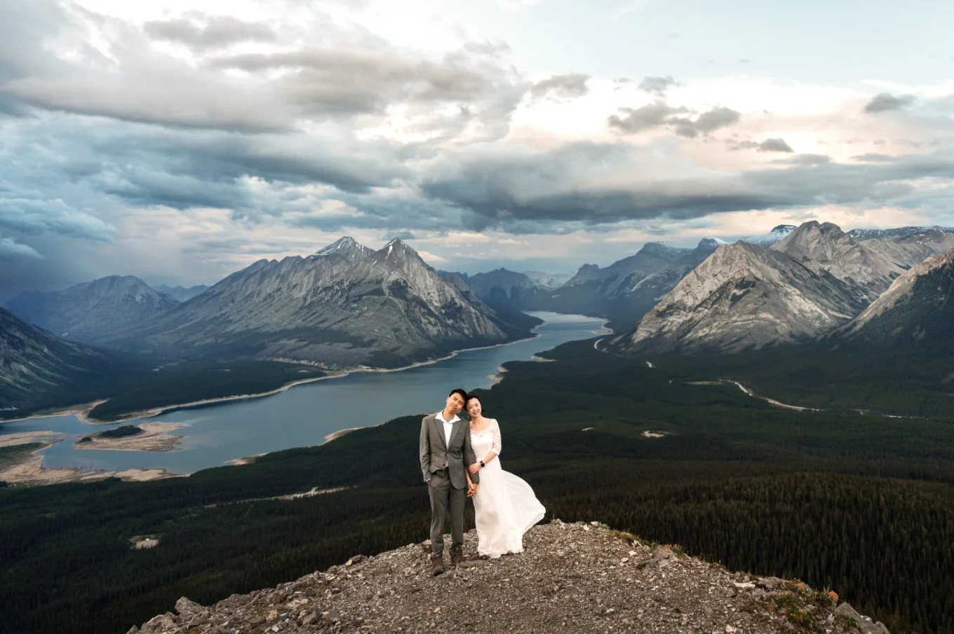 Newlyweds in the mountains looking at the camera and smile.