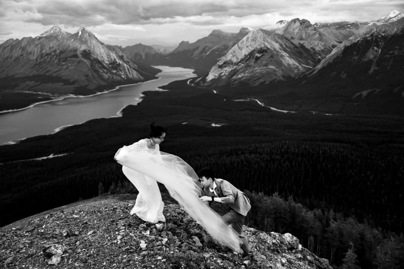 Photograph in black and white on the peak of the mountain when the groom hiked to rescue the brides veil.