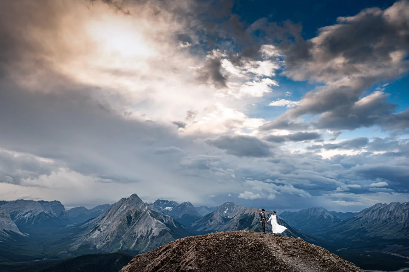 Hiking adventure during the sunset in the Canadian Rockies. Photo of the newlyweds in Banff on the top of the mountain.
