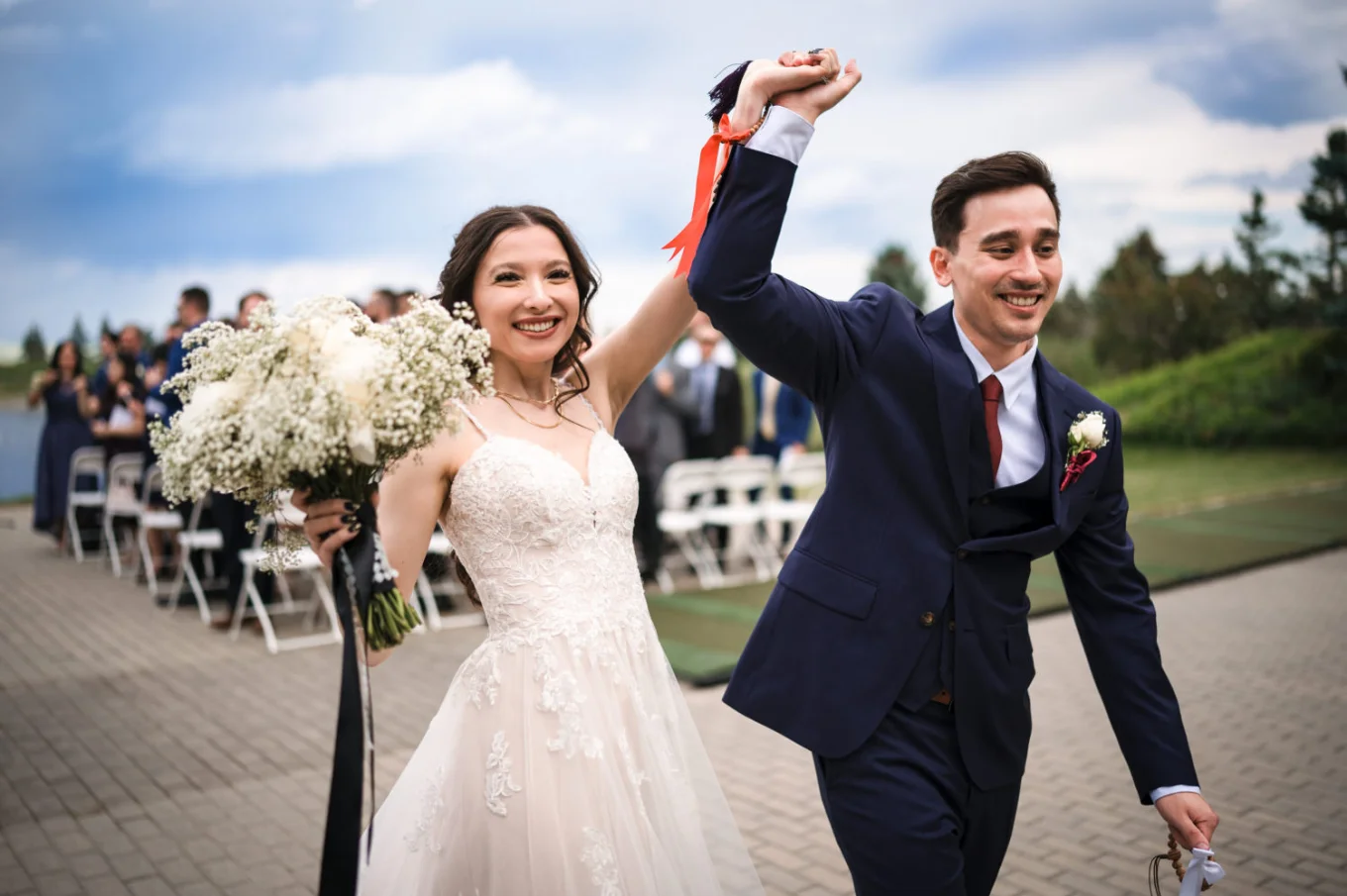 Happy newlyweds with their hands up after the Calgary Wedding Ceremony