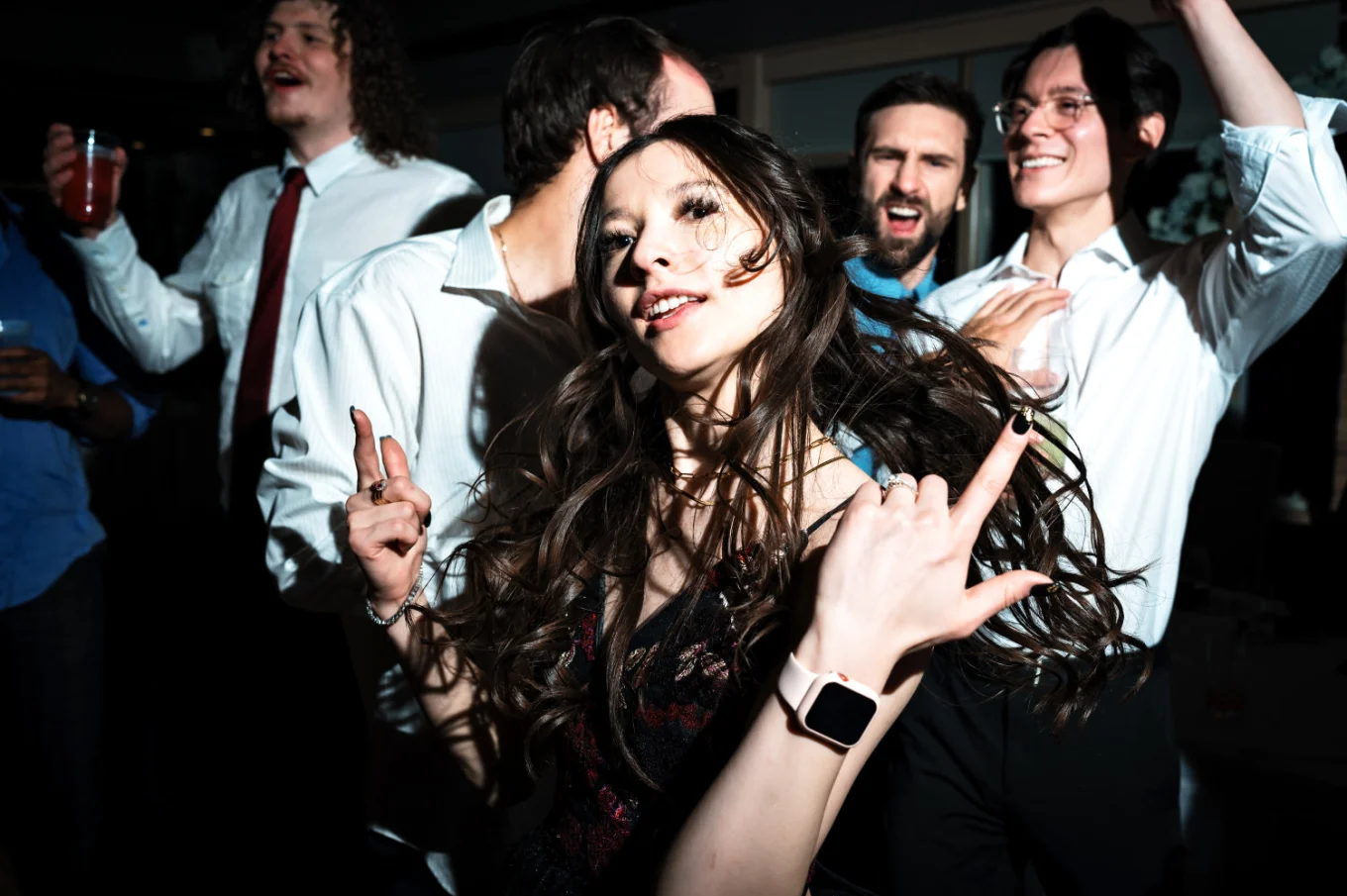 Bride is having fun on the dance floor behind her guests.
