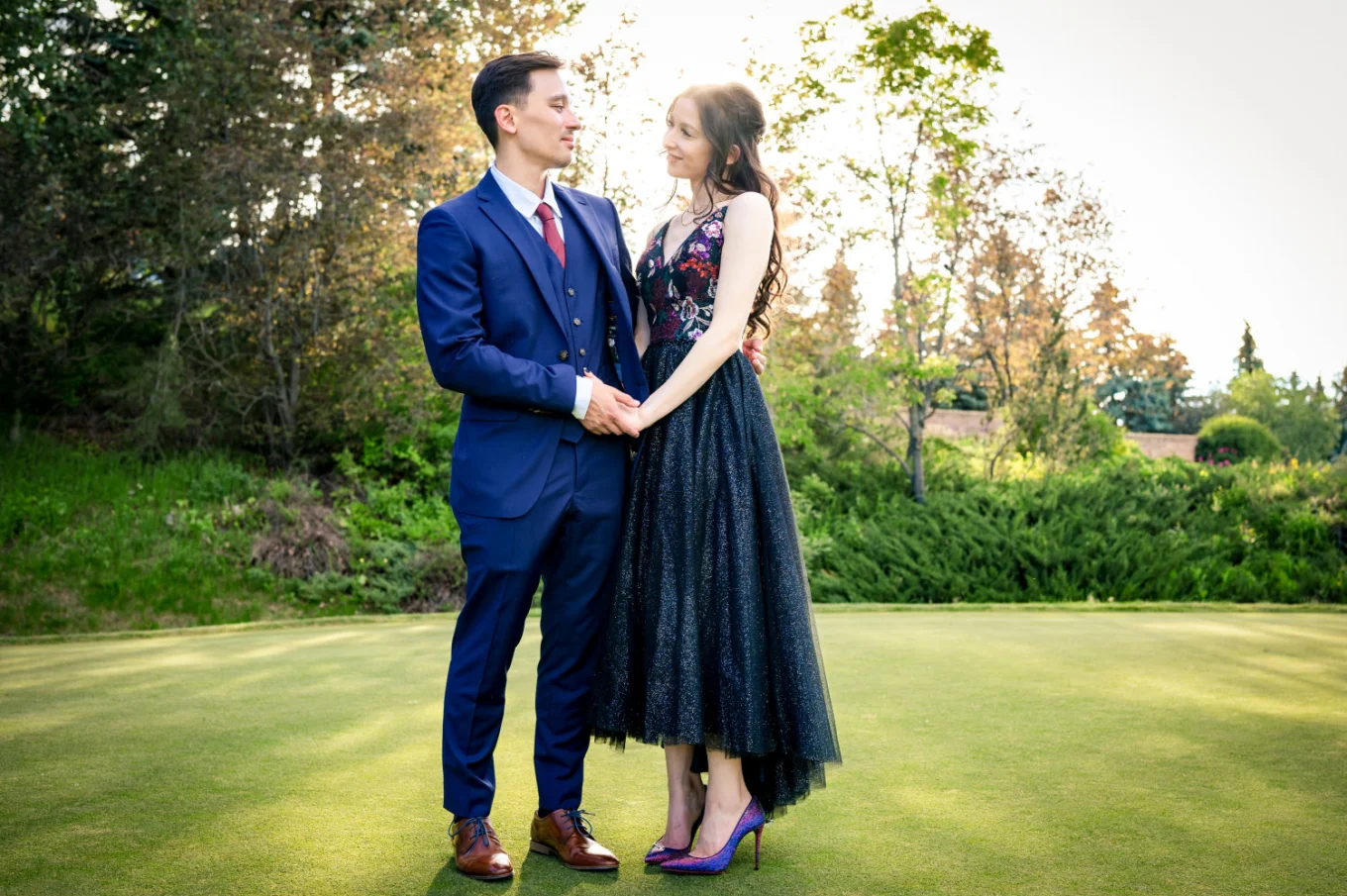 Newlyweds portrait while they holds hands and look at each other.