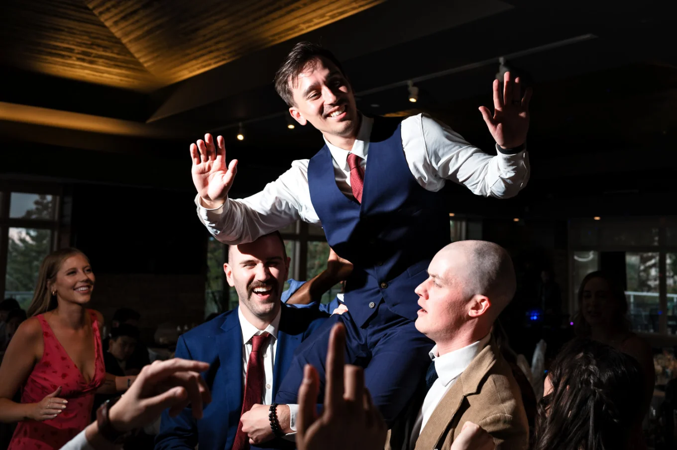 Best man and one of the guest lift the groom up during dance floor at the Calgary Wedding