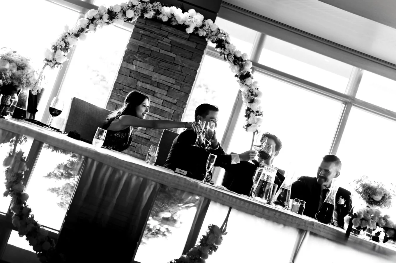 Creative photograph with the reflection of the wedding couple and the guests raising the classes