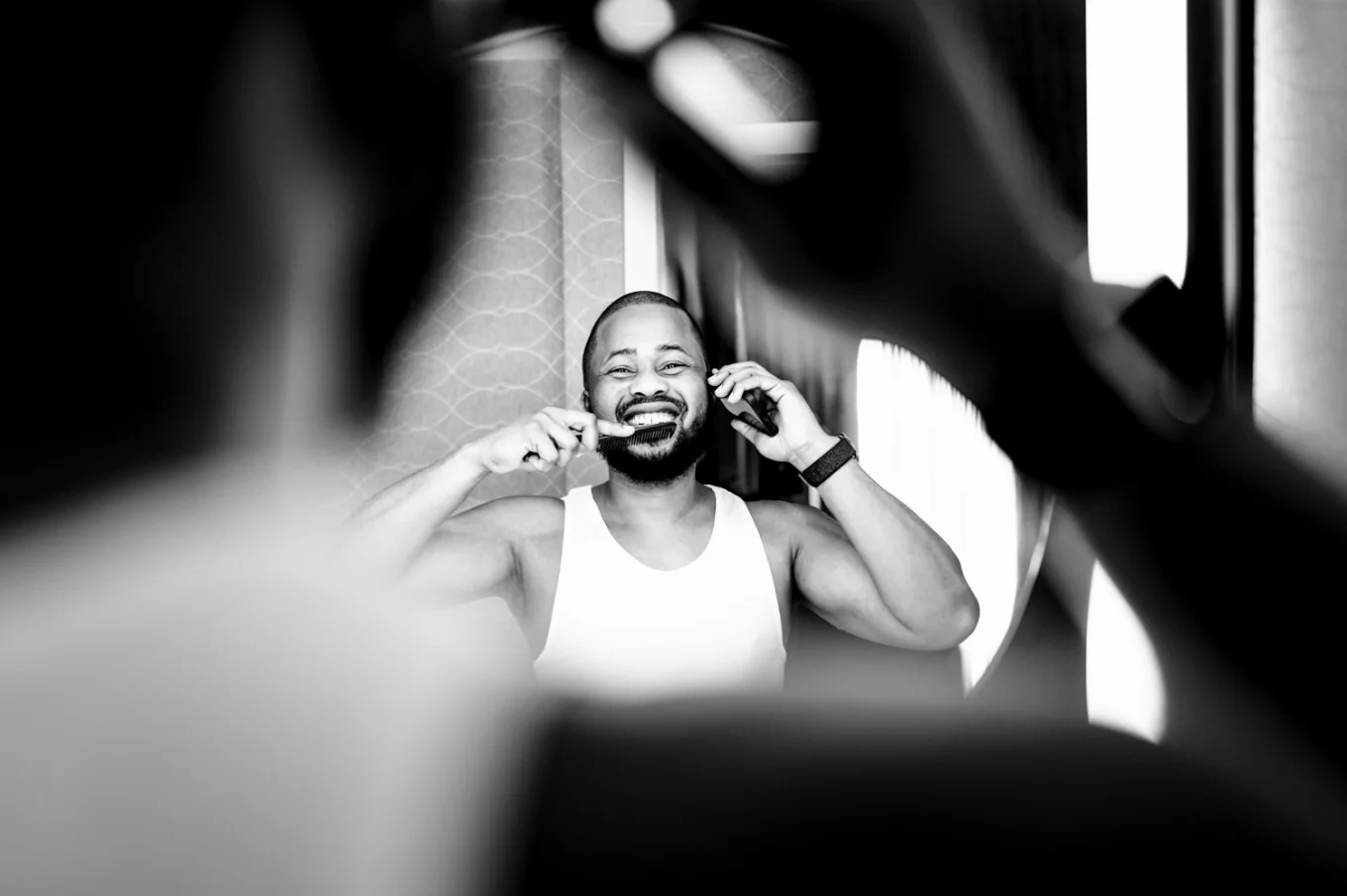 The groom brushes teeth and talk on the phone at the same time. Funny photograph taken by Calgary Wedding Photographer.